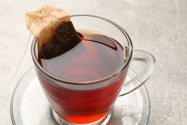 Çay demliyorum. Cam fincanda çay poşeti var.