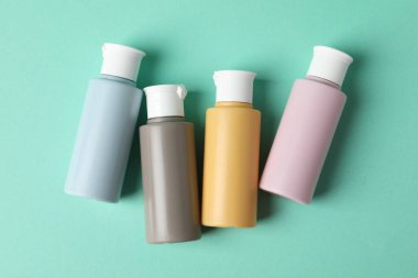 Turkuaz arka planda kozmetik seyahat seti, düz yatış. Banyo aksesuarları