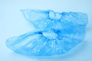 Açık mavi arka planda bir çift tıbbi ayakkabı kılıfı.