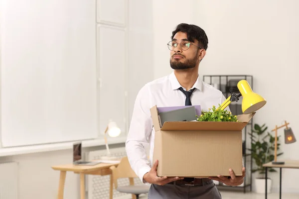 Unemployment problem. Frustrated man with box of personal belongings in office