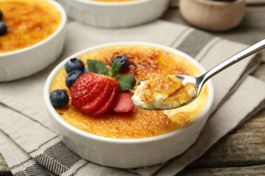Böğürtlenli ve nane şekerli nefis creme brulee 'yi ahşap masadan alıp, yakın plan