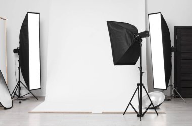 Stüdyoda beyaz fotoğraf ve profesyonel ışıklandırma ekipmanları