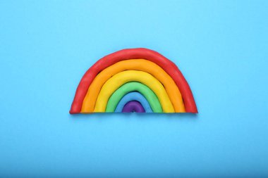 Açık mavi arkaplanda plastikten yapılmış güzel gökkuşağı, üst manzara