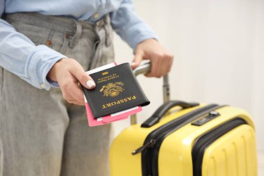 Bavullu bir kadın pasaport ve arka planda bilet veriyor, yakın plan.