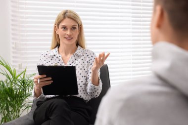 Ofiste genç bir çocukla çalışan psikolog.