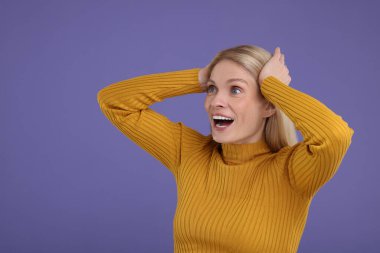 Mor arka planda şaşırmış kadın portresi, metin için boşluk