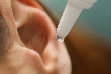 Tıbbi kulak damlası uygulayan kadın, makro görüş.