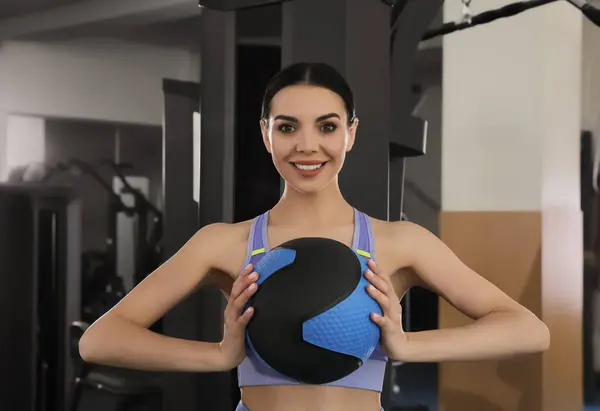 Sporty woman with medicine ball in modern gym