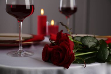 Beyaz masa üzerinde güller olan bir yer, yakın plan. Romantik yemek.