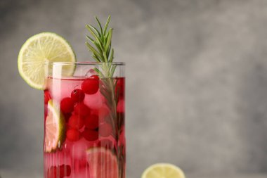 Gri arka planda biberiyeli ve limonlu lezzetli kızılcık kokteyli. Yakın plan. Metin için boşluk