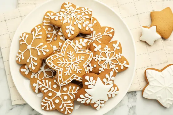 Lezzetli yıldız şekilli Noel kurabiyeleri beyaz mermer masa üzerinde krema, üst manzara