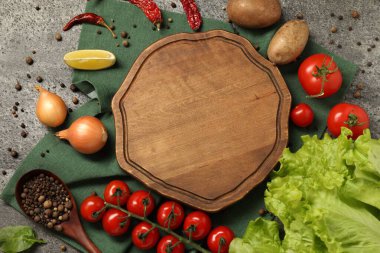 Yemek pişirme konsepti. Ahşap kesim tahtası ve gri desenli masa üzerinde farklı ürünler, düz yatak