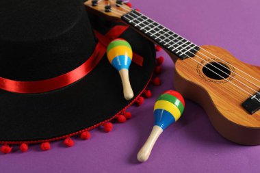 Siyah Flamenko şapka, ukulele ve marakas mor masada, yakın plan.