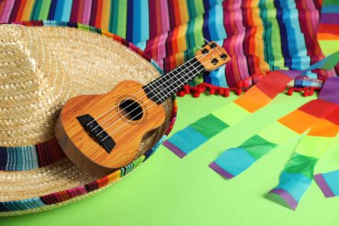 Meksika şapkası ve ukulele yeşil masada, yakın plan.