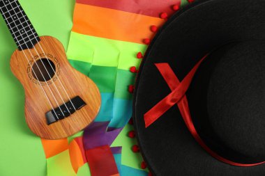 Yeşil arka planda siyah Flamenko şapka ve ukulele.