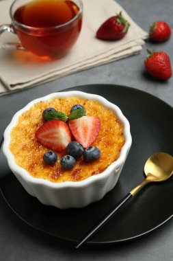 Böğürtlenli nefis creme brulee ve gri masadaki nane şekeri, yakın plan