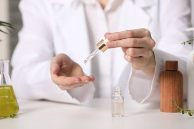 Dermatolog, beyaz masa içerisindeki temel yağı test ediyor.