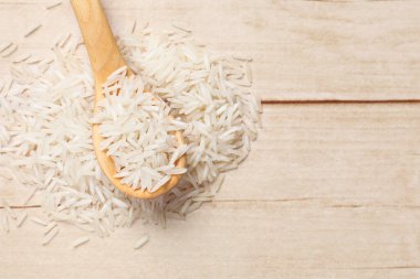 Çiğ basmati pilavı ve kaşık beyaz ahşap masa, üst manzara. Metin için boşluk