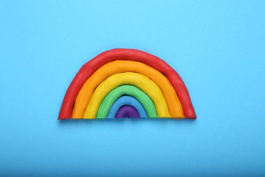 Açık mavi arkaplanda plastikten yapılmış güzel gökkuşağı, üst manzara