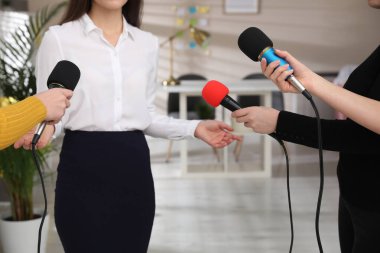 Bir grup gazeteci odada kadınlarla röportaj yapıyor, yakın plan.