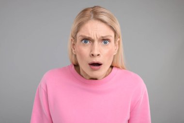 Gri arka planda şaşırmış kadın portresi