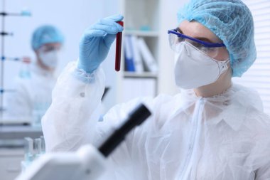 Laboratuvarda test tüpünde numuneyle çalışan bilim adamı.