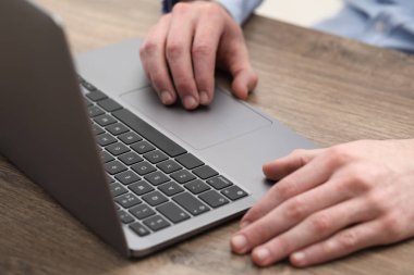 E-öğrenme. Çevrimiçi ders sırasında masadaki bilgisayarı kullanan adam, yakın plan.