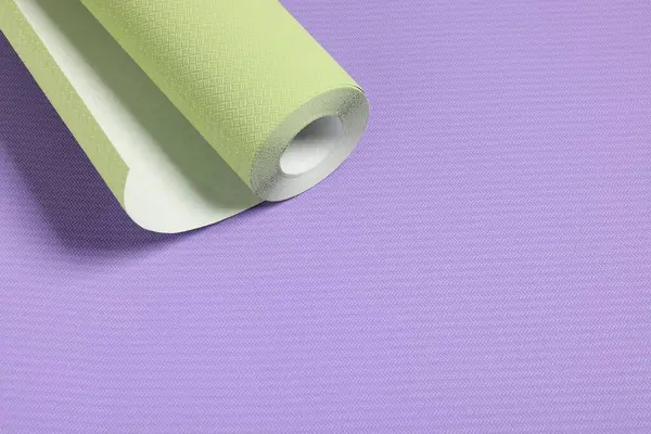 One green wallpaper roll on violet sample, space for text
