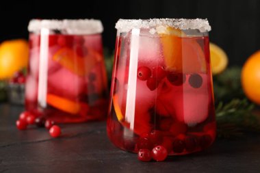 Koyu gri masadaki buzlu buzlu, lezzetli yabanmersini kokteyli.