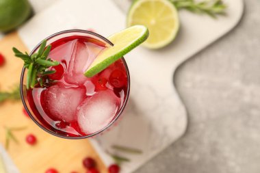 Biberiyeli yaban mersini kokteyli ve gri masada limon, üst manzara. Metin için boşluk