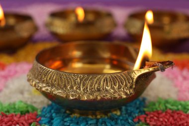 Diwali kutlaması. Renkli rangoli üzerine Diya lambaları, yakın plan