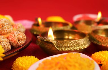 Diwali kutlaması. Diya lambaları ve lezzetli Hint tatlıları masada, yakın plan
