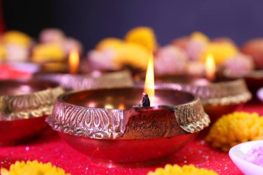 Diwali kutlaması. Diya lambaları parlak kırmızı masada, yakın plan