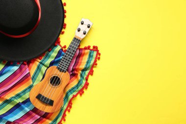 Meksika şapkası, gitar ve sarı arka planda renkli panço düz yatıyordu. Metin için boşluk