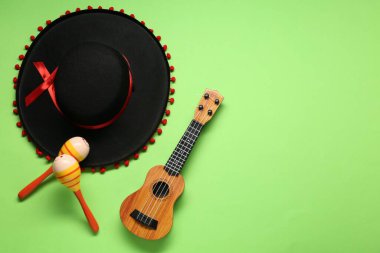 Meksika şapkası, marakas ve yeşil arka planda gitar, düz yatış. Metin için boşluk