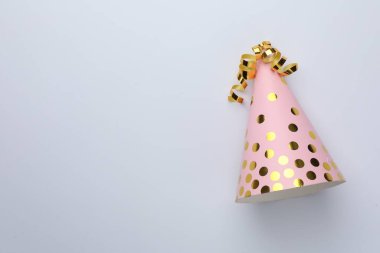 Pembe bir parti şapkası. Arka planda yılan desenli süslemeler var. Üst manzara. Metin için boşluk