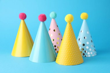 Colorful party hats on light blue background