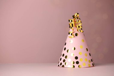 Tozlu pembe arka planda parti şapkası ve yılan desenleri, metin için yer