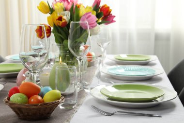 Paskalya kutlaması. Güzel çiçekli ve boyalı yumurtalı şenlik masası.