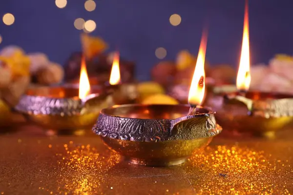 ディワリのお祝い 光沢のある金色のテーブルにディヤランプ クローズアップ — ストック写真