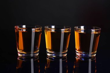 Ayna yüzeyinde shot bardaklarıyla alkol içilir, yakın plan.