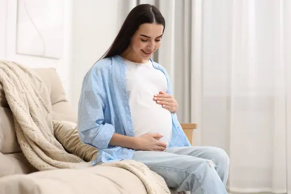 Ευτυχισμένη Έγκυος Γυναίκα Στον Καναπέ Στο Σπίτι — Φωτογραφία Αρχείου