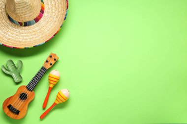 Meksika şapkası, marakas, oyuncak kaktüs ve yeşil arka planda gitar, düz yatış. Metin için boşluk