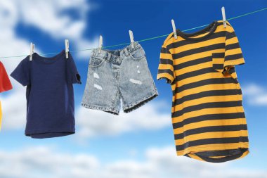 Different clothes drying on washing line against blue sky