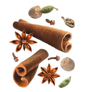 Tarçın çubukları ve beyaz arkaplana dökülen diğer aromatik baharatlar