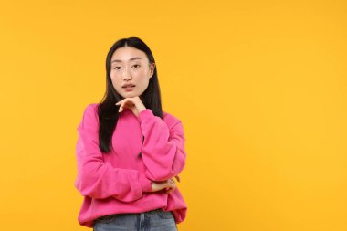 Turuncu arka planda güzel bir kadının portresi. Metin için boşluk