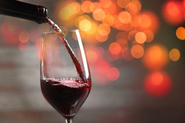 Arka plana kırmızı şarap dökmek bulanık ışıklarla, yakın plan. Metin için boşluk