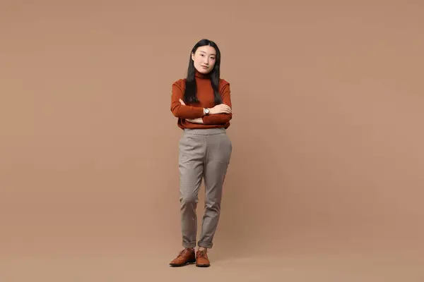 Stock image Full length portrait of beautiful woman with crossed arms on brown background