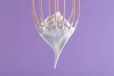 Menekşe arkaplanda çırpılmış krema, yakın plan.