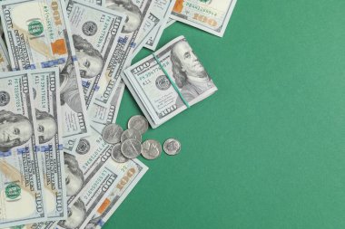 Para değişimi. Yeşil arka planda dolar banknotları ve madeni paralar, düz yatış. Metin için boşluk